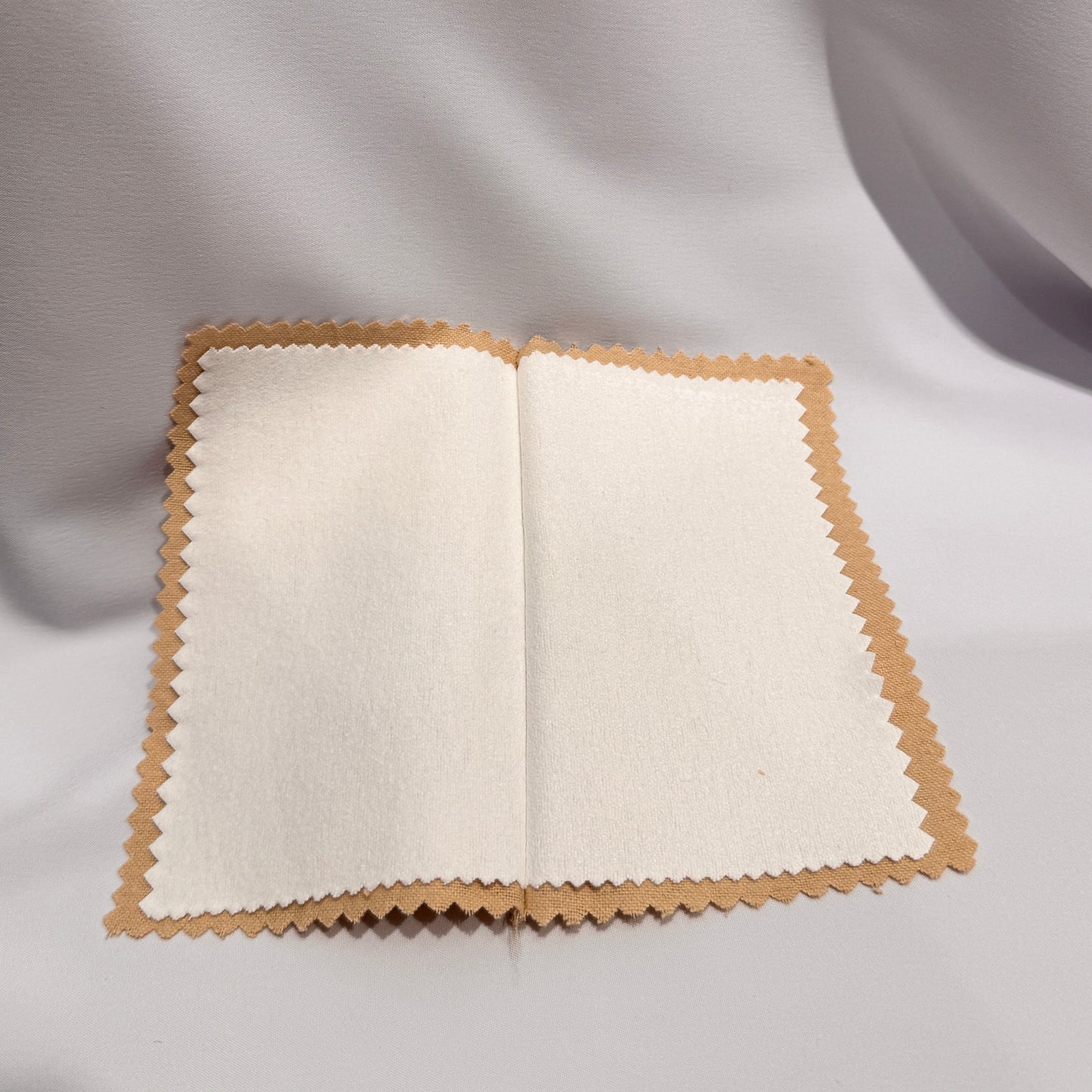 Open jewelry cloth with beige cover on a gray background
