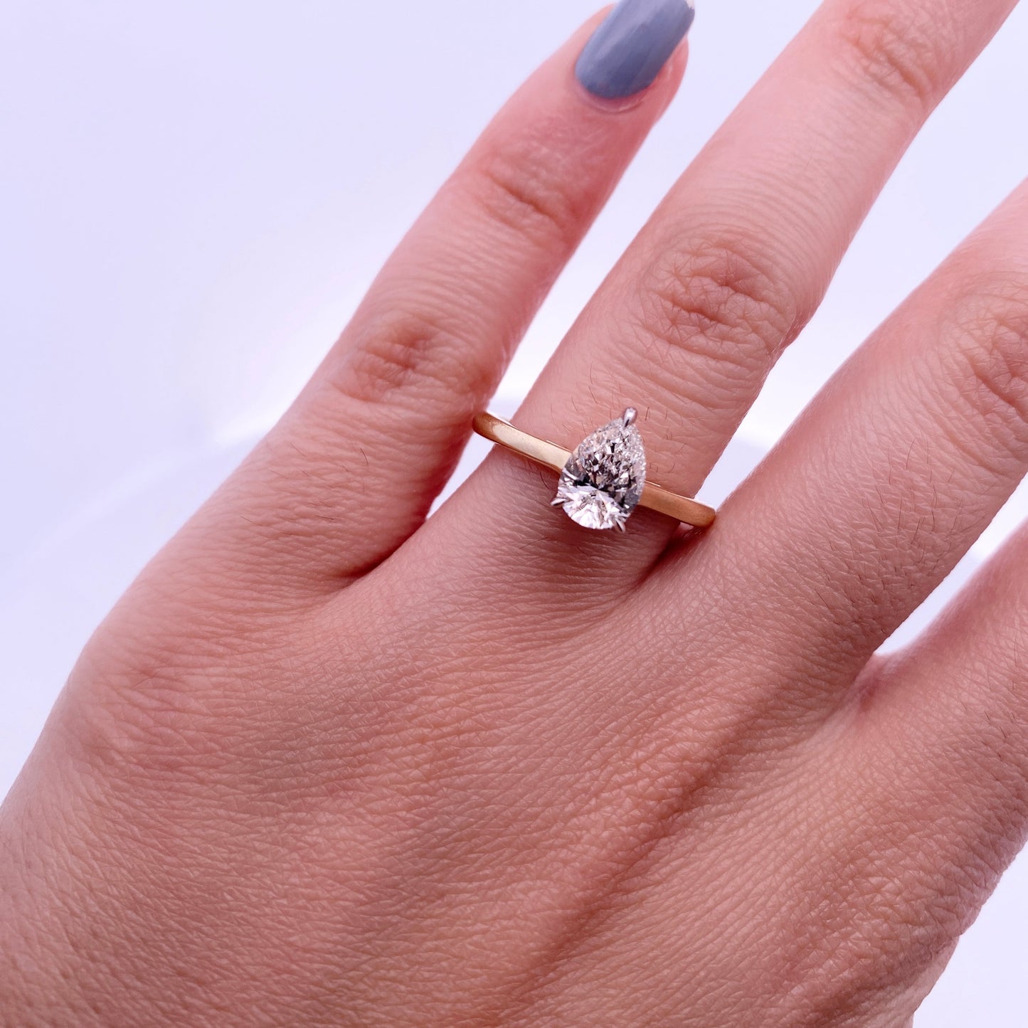 Close up of model wearing the 14K Gold Diamond Pear-Shaped Engagement Ring with Halo