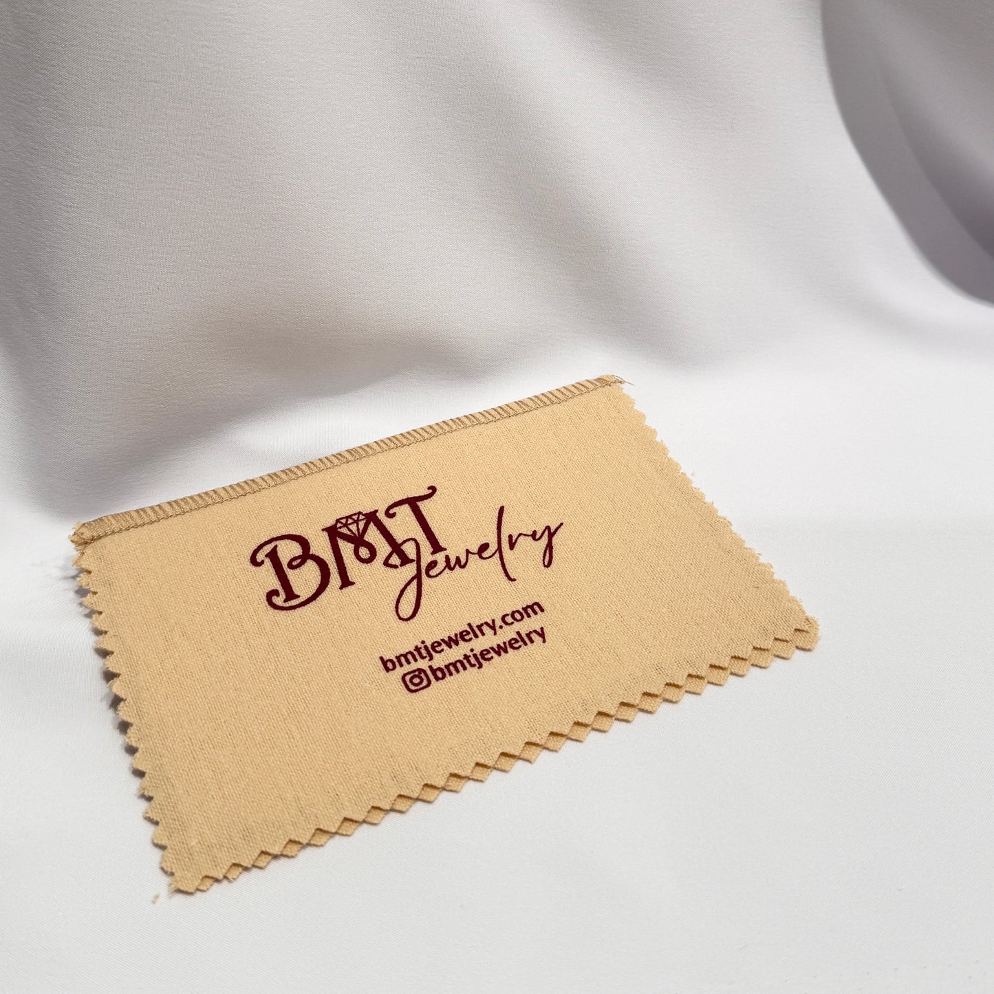 BMT Jewelry beige cloth with a white background