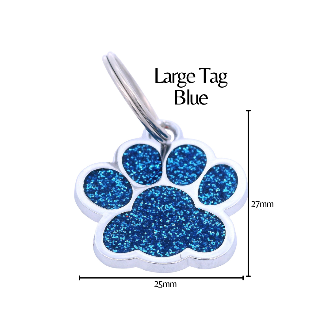 Pink glitter paw print tag with dimensions on a white background. There is black text that says "Large Tag Blue" and the height is labeled as 27mm and the width as 25mm.