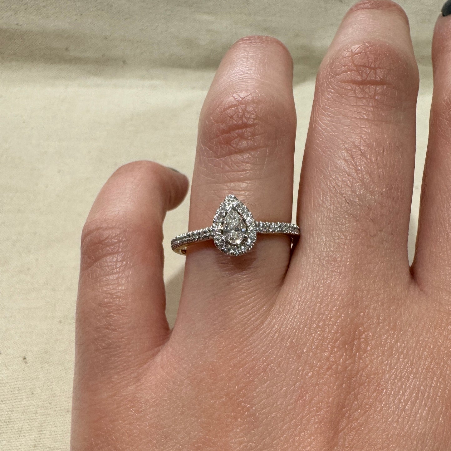 Close up of model wearing 10K Yellow Gold Pear-Shaped Diamond Engagement Ring with Halo
