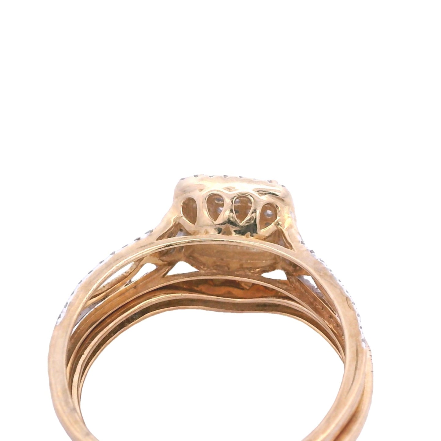 Angled aerial view of yellow gold bridal set. The engagement ring setting has a trapezoid shape. It has four teardrops on that setting that are connecting to the main band.