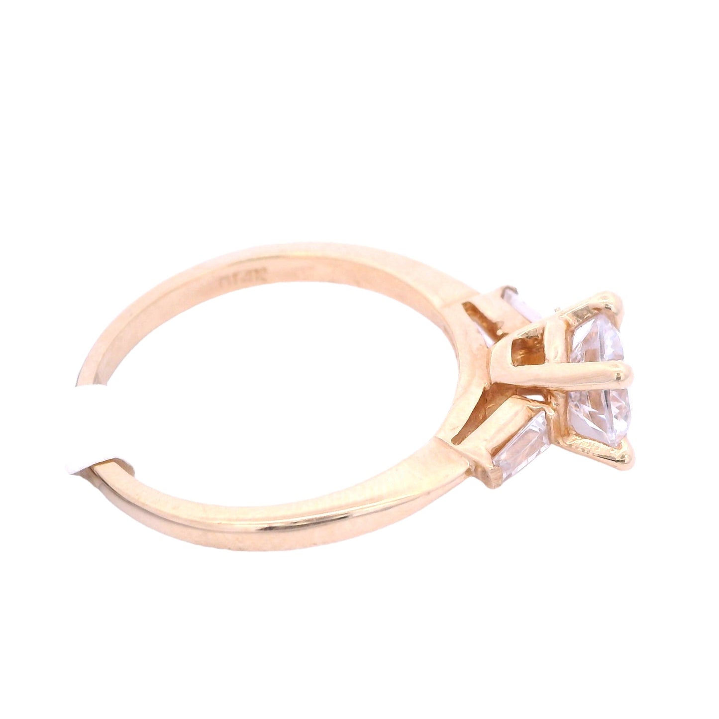 Side areal view of yellow gold engagement ring with white round zirconia in the center. there is a single baguette laying horizontally on the band on each side of the center.