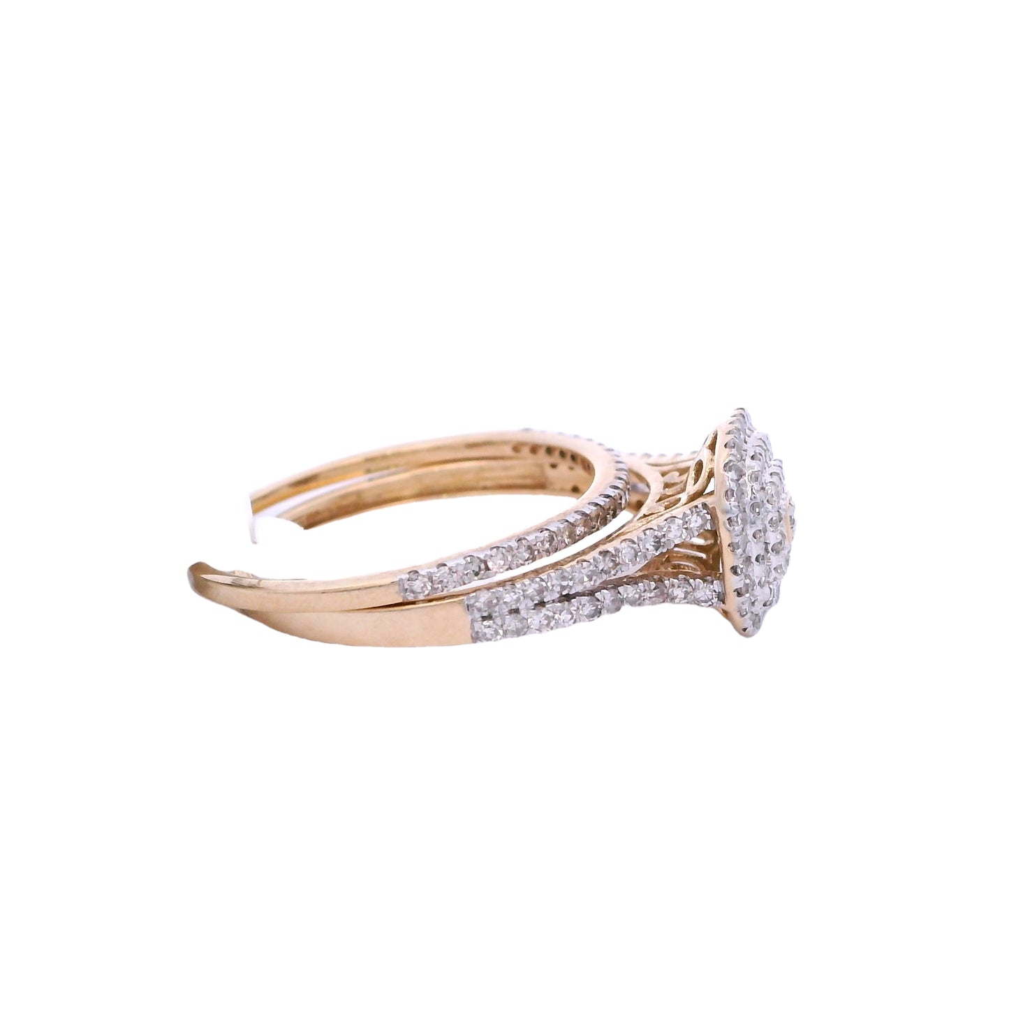 Side view of gold bridal set. The engagement ring has a cushion center with small round diamonds. The small round diamond in the center is outlined in gold. The ring also has a double halo with small round diamonds. The engagement ring band has two rows of round diamonds that merge into one row on each side. The wedding band has small round diamonds and is laying perfectly over the engagement ring.