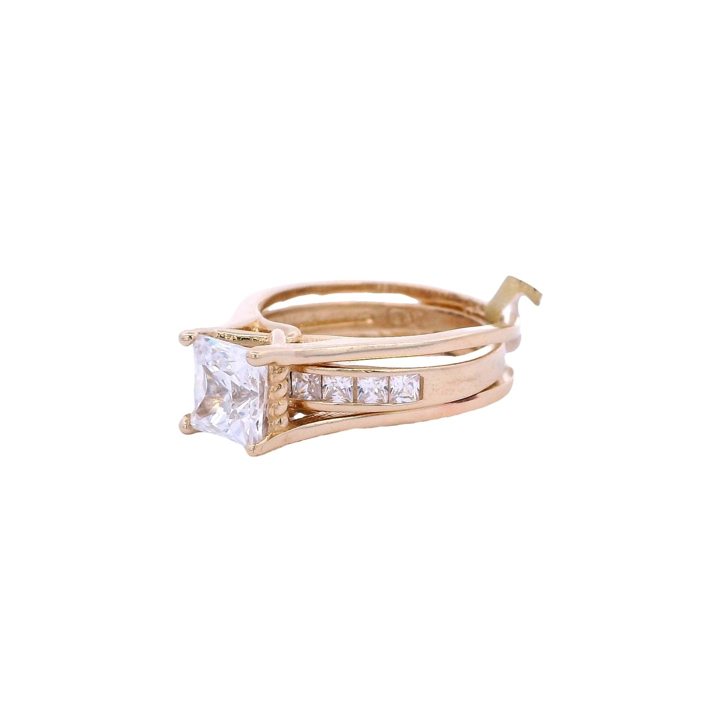 Side view of yellow gold bridal ring set. The engagement ring has two bands on each side and a princess cute white zirconia in the center. The wedding band is inside the engagement ring. It has smaller princess cut white zirconia on the front of the band.