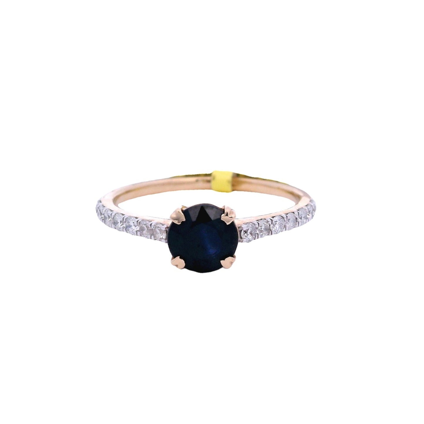Front view of yellow gold ring with a round blue sapphire in the center. The sapphire is held by 4 yellow gold prongs. There are white round zirconia on both sides of the band.