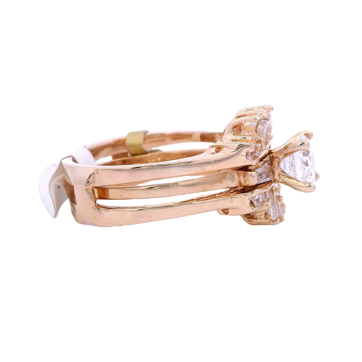 Side view of gold bridal ring. The engagement band has a single white zirconia with a baguette zirconia on each side. The ring is inside a ring enhancer that has round and baguette white zirconia.