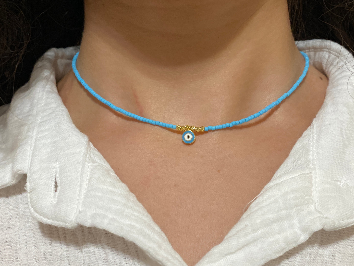Baby Blue, White, and Silver Gold-Plated Evil Eye Round Pendant Necklace with Baby Blue Beads on model
