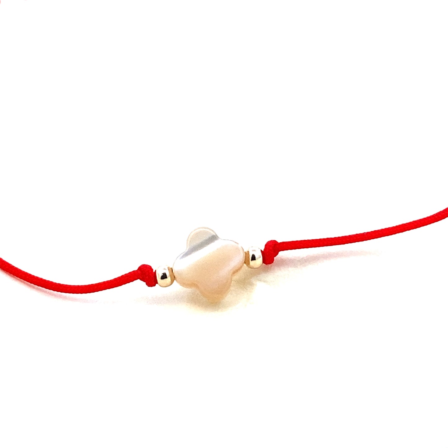 Handmade adjustable red string bracelet with a Mother of Pearl clover in the center and 2 gold beads on each side. Close up