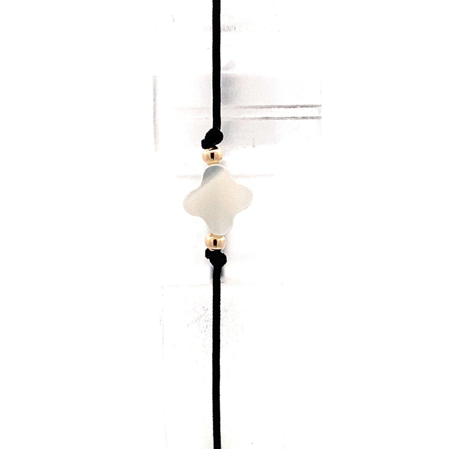 Handmade adjustable black string bracelet with a Mother of Pearl clover in the center and 2 gold beads on each side. Close up