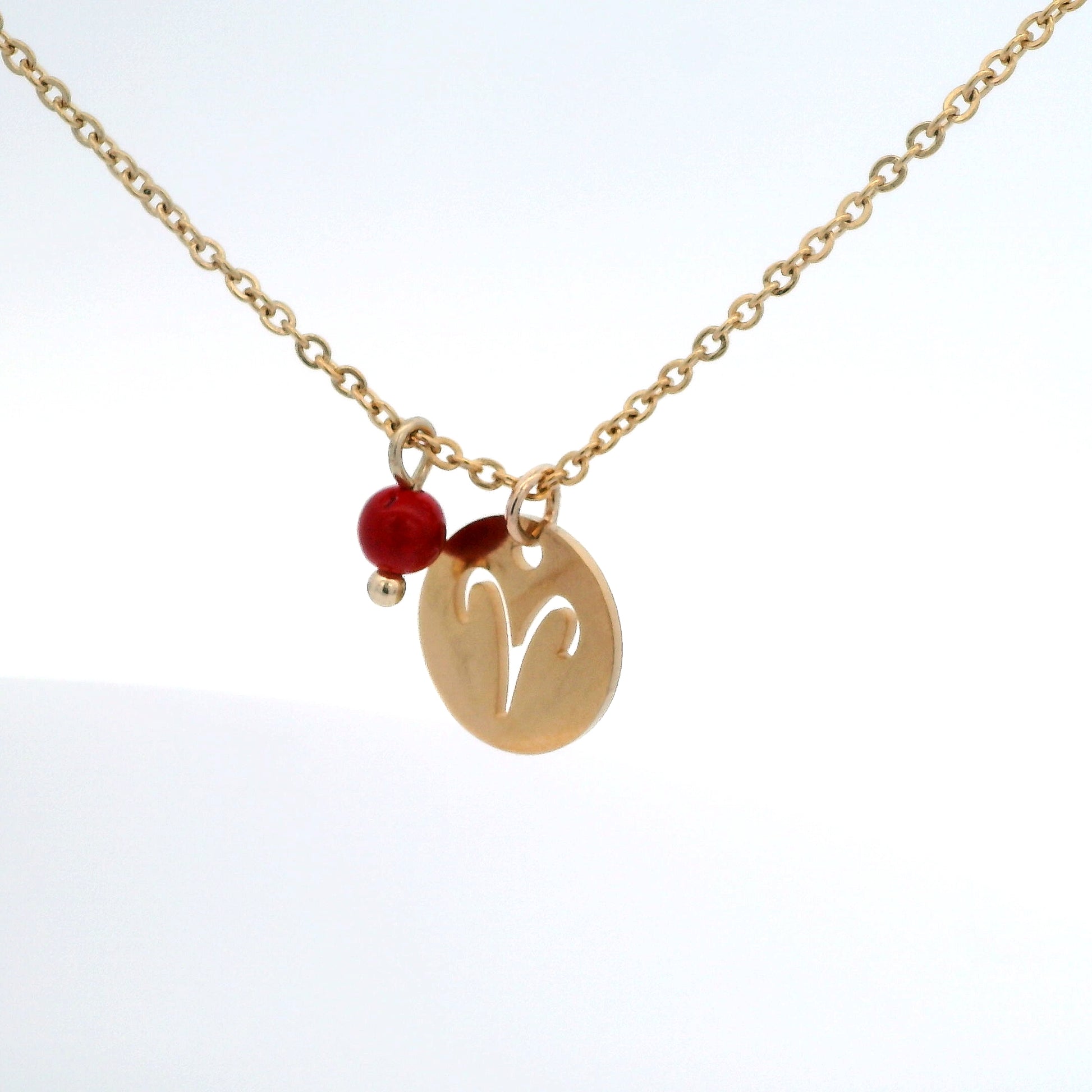 A gold-plated stainless steel chain necklace with a round gold disc pendant featuring a cutout symbol of the Aries zodiac sign, adorned with a small bead, on a white background.