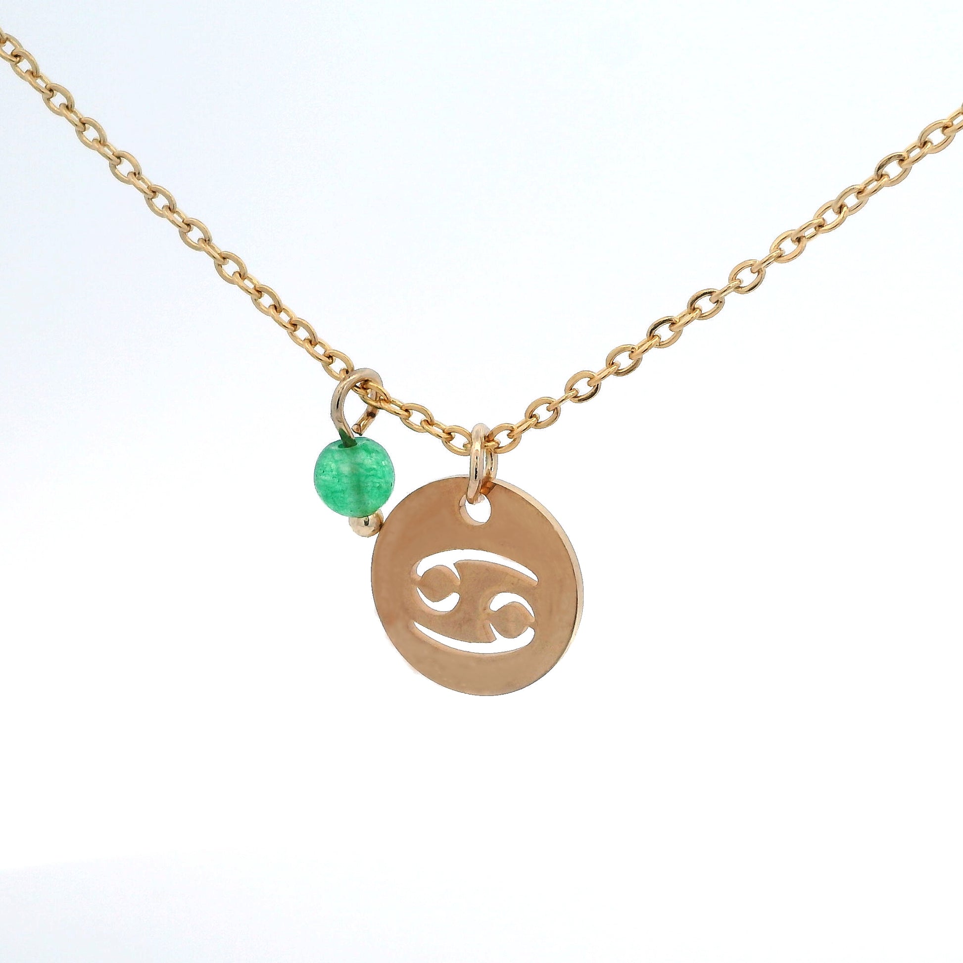 A gold-plated stainless steel chain necklace with a round gold disc pendant featuring a cutout symbol of the Cancer zodiac sign, adorned with a small bead, on a white background.