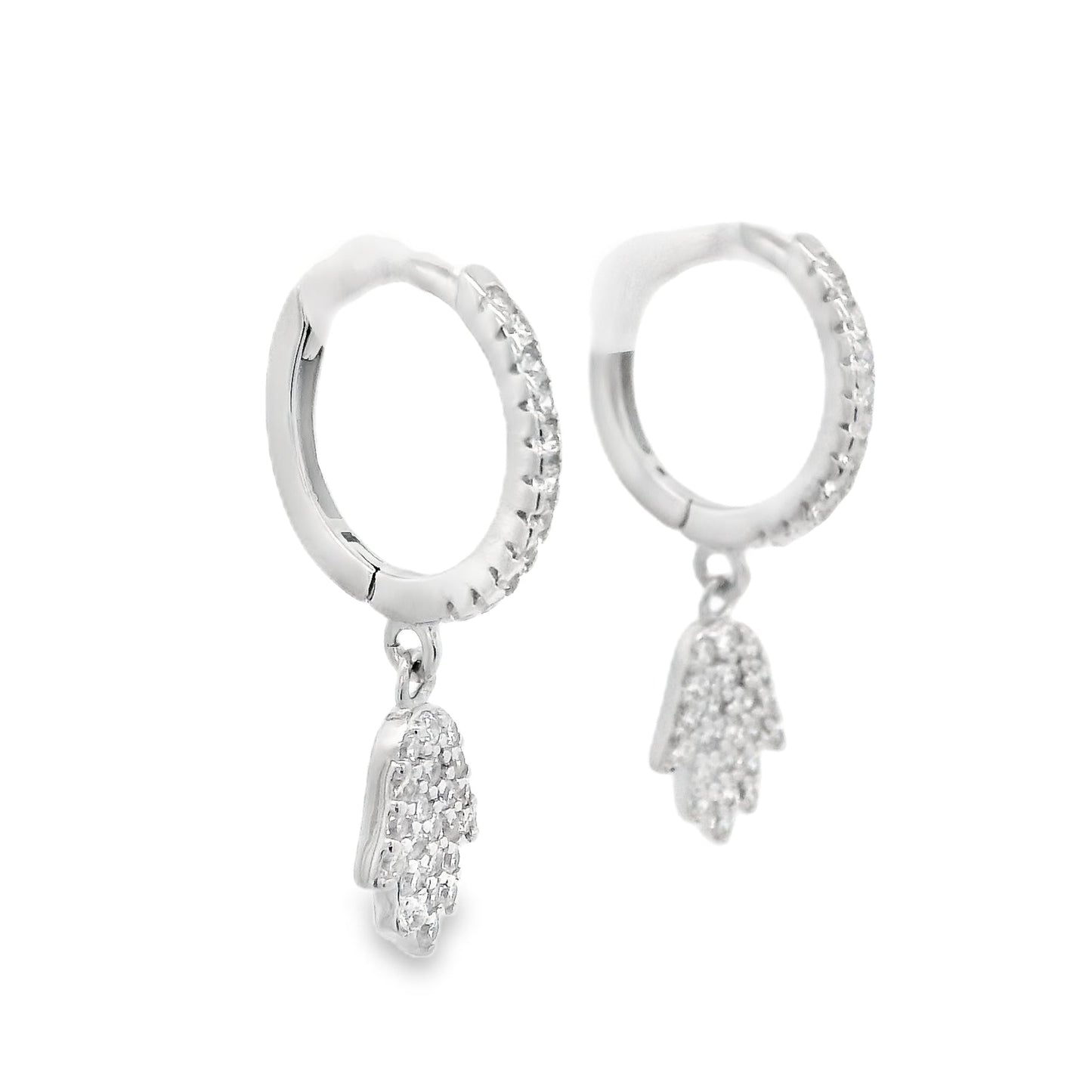 Angled side view of silver hoops with round clear zirconia and a hamsa hand that dangles below each huggie that also has round zirconia inside it.