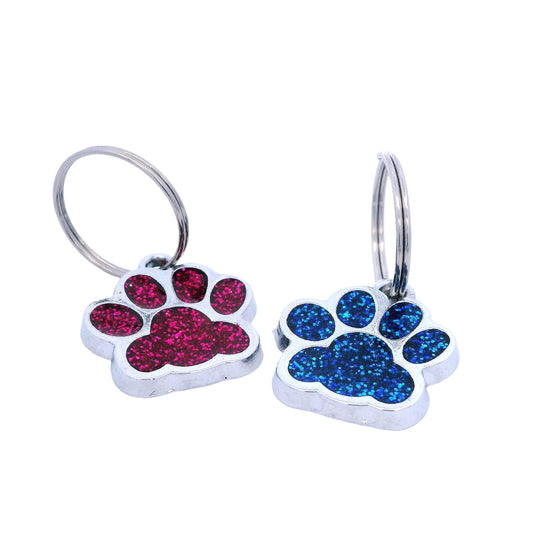 Two small paw-shaped keychains, one pink and one blue, on a white background.