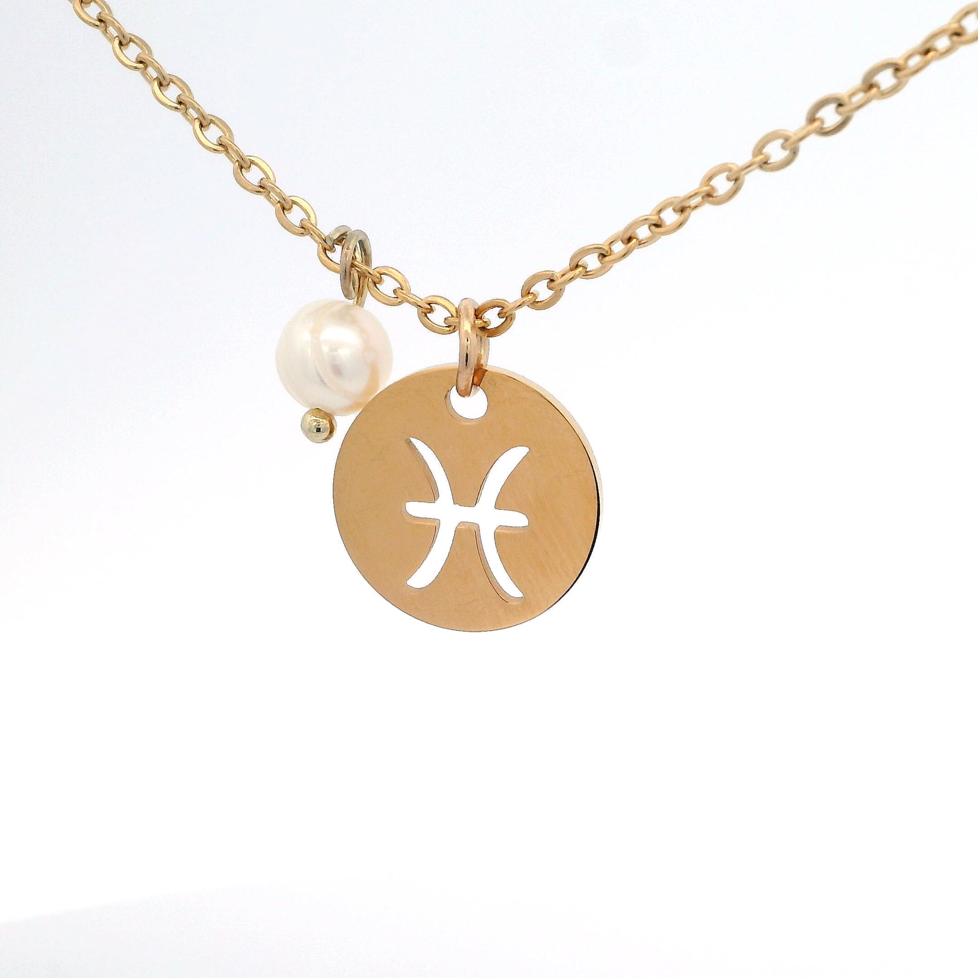 A gold-plated stainless steel chain necklace with a round gold disc pendant featuring a cutout symbol of the Pisces zodiac sign, adorned with a small bead, on a white background.