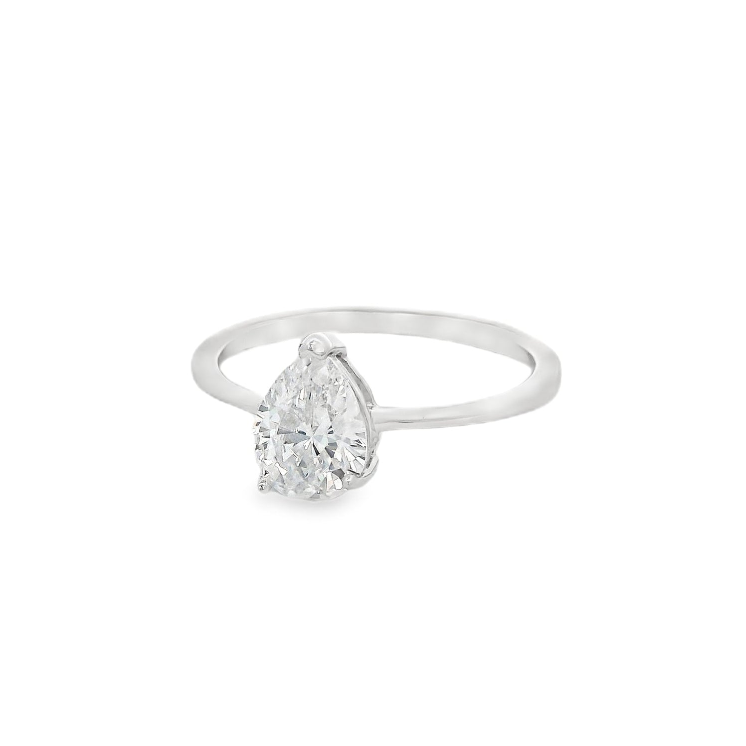 Side angle view of silver engagement ring that has a thin solid band and a clear teardrop shaped zirconia in the center.