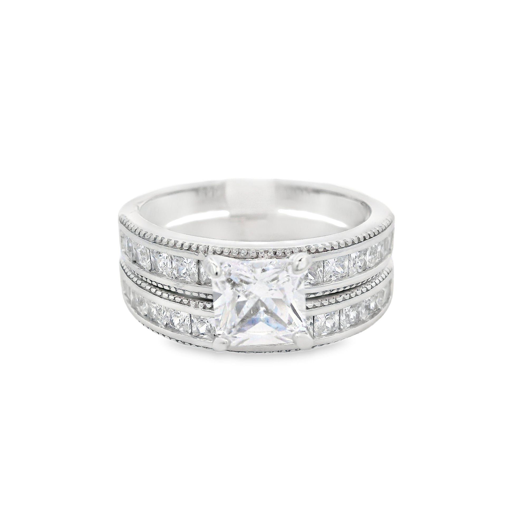 Front view of two of the rings: the engagement ring and smaller wedding band. The wedding band is on the bottom; it has small square zirconia. The engagement ring is on top. It has a large square zirconia in the center and smaller square zirconia on each side.