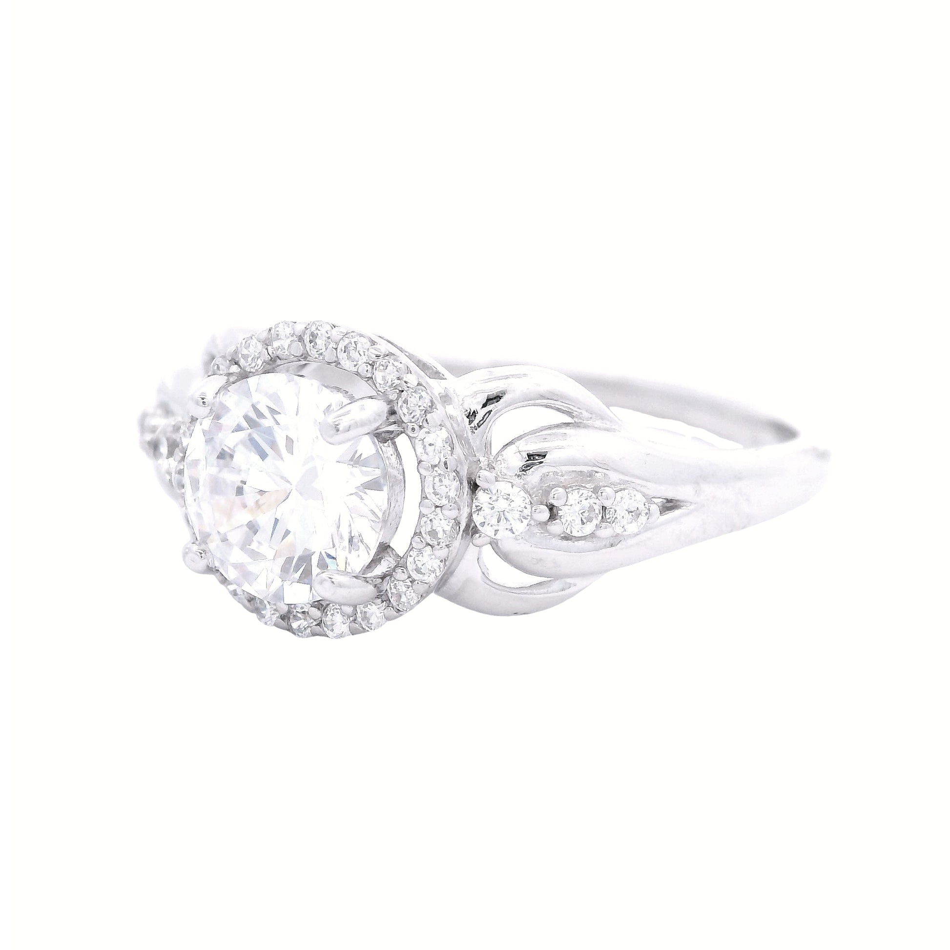 Angled view of sterling silver ring with round-shaped zirconia in the center and a round halo.  It has decorative swirls with round zirconia accents on each side.